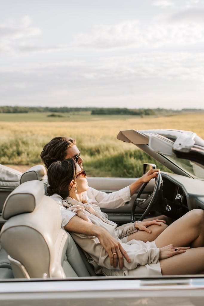 Particuliers A couple enjoys a romantic drive through scenic fields in a stylish convertible.